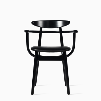 Vincent Sheppard Teo dining armchair with a black upholstered seat and dark wooden frame, featuring curved armrests