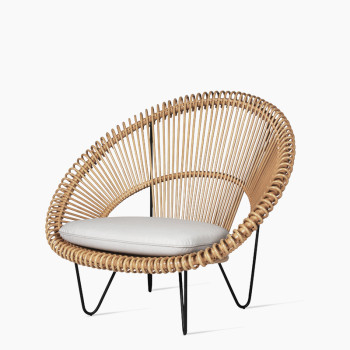 Vincent Sheppard Cruz Cocoon chair in natural rattan with a circular frame, black metal legs, and a light grey cushion