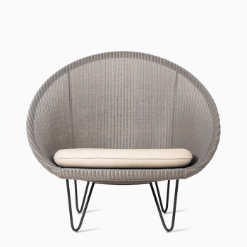 Vincent Sheppard Joe Cocoon chair with a matte grey woven frame, black metal legs, and a beige cushion