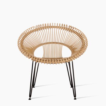 Vincent Sheppard Roy Loungesessel aus natürlichem Rattan mit einem offen gewebten, kreisförmigen Design und schlanken Metallbeinen.