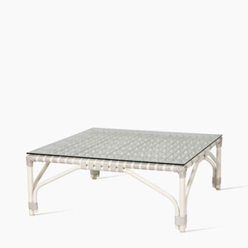 Vincent Sheppard Lucy coffee table in off white with a woven rattan frame and a square glass top.