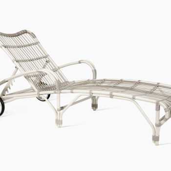 Vincent Sheppard Loop sunlounger in off white with a woven rattan design, adjustable backrest, curved armrests, and wheels for mobility.