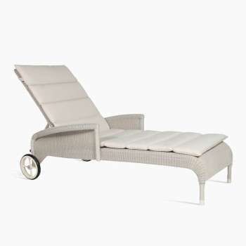 Vincent Sheppard Safi sunlounger in old lace with armrests, adjustable backrest, and cushioned seating, featuring a woven rattan design and wheels for easy mobility.