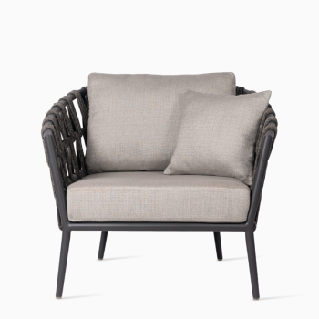 Vincent Sheppard Leo lounge chair in lava with linen-coloured cushions, featuring a rope-woven backrest and cushioned seat for enhanced comfort.