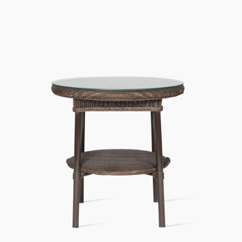 : Table d'appoint Avignon de Vincent Sheppard en cuivre avec un plateau rond en verre et un design en rotin tressé, dotée d'une étagère inférieure pour un rangement supplémentaire.