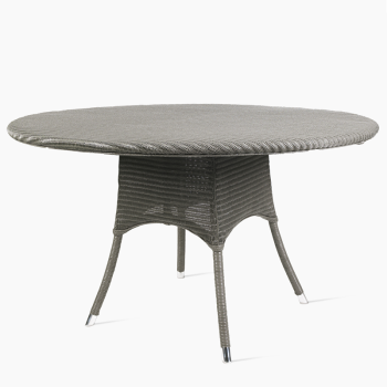 Vincent Sheppard Nimes round dining table in quartz grey with a woven rattan design and sleek, tapered legs.