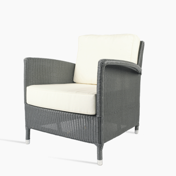 Fauteuil lounge Vincent Sheppard Dovile en Oyster avec des coussins blancs.