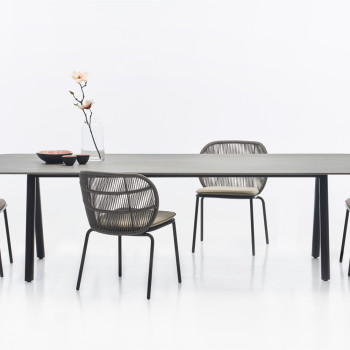  Vincent Sheppard Kodo dining set featuring a flint dining table with fossil grey legs, surrounded by Kodo dining chairs in fossil grey with cushions.