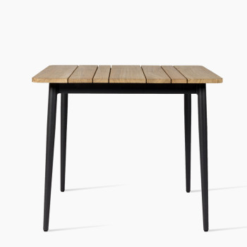 Vincent Sheppard Max dining table with an untreated teak slatted tabletop and black metal legs.