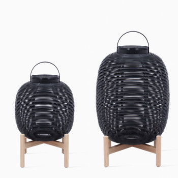 Pair of Vincent Sheppard Tika lanterns in black with teak wood bases and black covers, featuring a woven design and round shapes in different sizes.