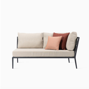 Vincent Sheppard Leo modular corner sofa with a lava-coloured frame, almond cushions, and decorative spicy and coral cushions.