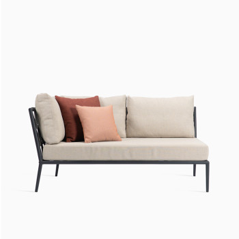 Vincent Sheppard Leo modular corner sofa with a lava-coloured frame, almond cushions, and decorative spicy and coral cushions.