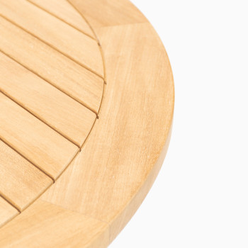 Close-up of the Vincent Sheppard Charlie bistro table, featuring a round, slatted teak top.