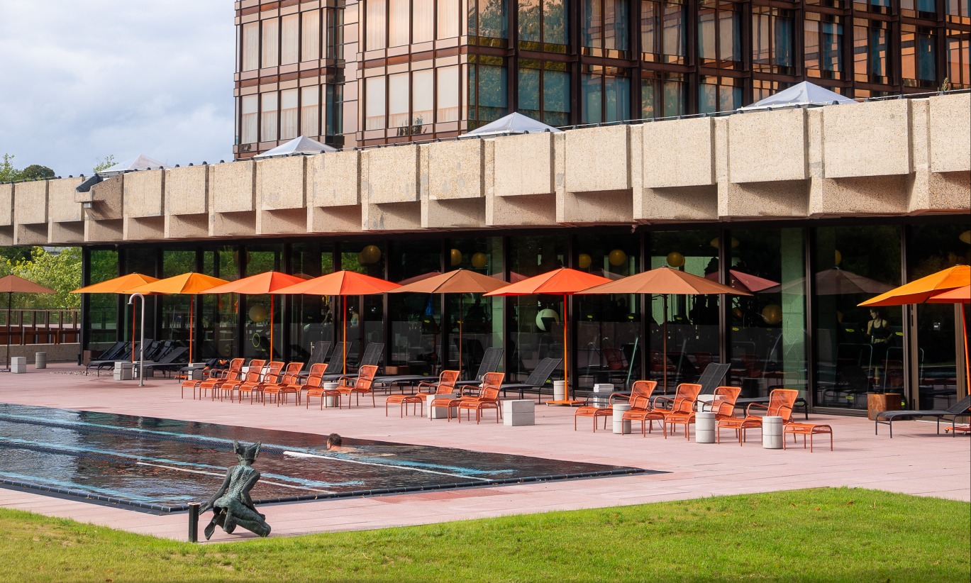 Hôtel Mix Brussels avec le bâtiment Royal Belge, doté d'une terrasse avec des chaises longues et repose-pieds Loop de couleur terracotta de Vincent Sheppard, et une piscine.