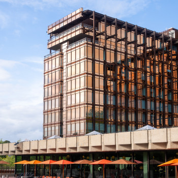 Mix Brussels Hotel mit dem Royal Belge Gebäude, mit einer Terrasse mit terrakottafarbenen Loop-Loungesesseln und Fußstützen von Vincent Sheppard und einem Schwimmbad.