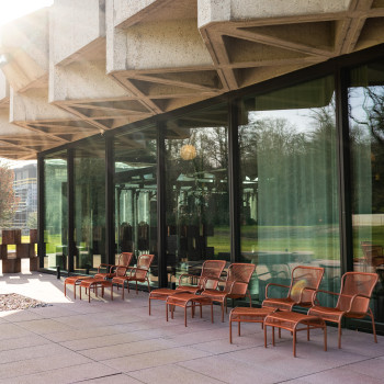 Terrasse an der Seite des Royal Belge-Gebäudes in Brüssel mit terrakottafarbenen Loop-Loungesesseln und Loop-Fußhockern von Vincent Sheppard.