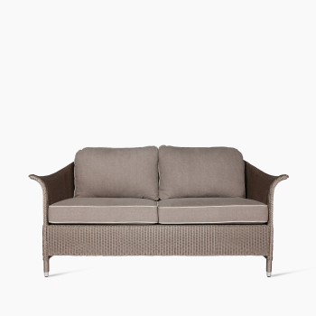 Vincent Sheppard Victor 2.5-seater lounge sofa with a woven frame in natural tones and taupe cushions