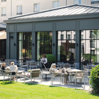 Outdoor seating area at Duke's Palace in Brugge with David Dining armchairs, David lounge chair, and David lounge sofa 2S.