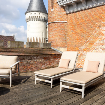 Dachterrasse im Duke's Palace in Brügge mit David-Liegestühlen, David-Loungesessel und rundem Tisch, mit Blick auf die Türme und roten Backsteinmauern des Schlosses.