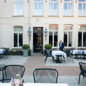  Terrasse de l'Hôtel Cobergher à Courtrai avec des chaises de salle à manger et des fauteuils de la collection Loop