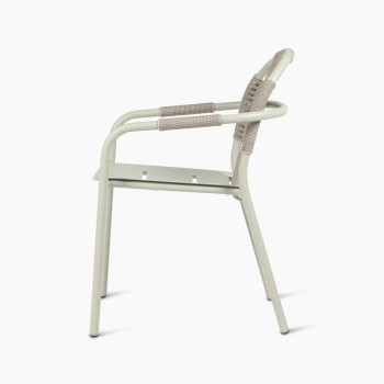 Side view of Vincent Sheppard Cleo dining armchair in sage green, featuring a woven backrest and aluminium frame.