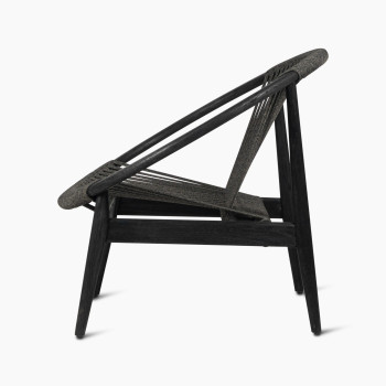 Vincent Sheppard Frida lounge chair in Onyx Black, side view showcasing the dark wooden frame and angled woven backrest.