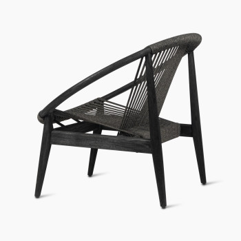 Fauteuil lounge Frida de Vincent Sheppard en Onyx Black, présenté sous un angle de 135 degrés, mettant en valeur le cadre en bois foncé et le dossier tressé.