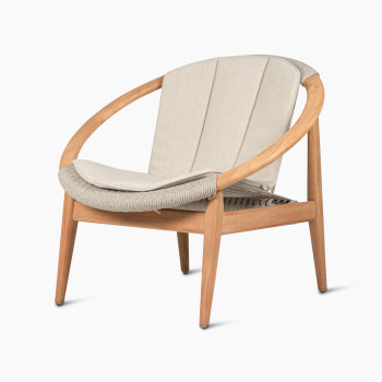  Vincent Sheppard Frida lounge chair in dune white with a round teak frame and a beige seat cushion, viewed at a 45-degree angle.