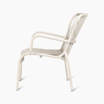 Side view of the Loop Lounge Chair in dune white by Vincent Sheppard, highlighting its curved armrests and woven rope seat.