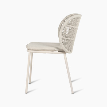 Side view of Vincent Sheppard Kodo dining chair with a dune white frame and almond seat cushion.