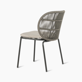 Vincent Sheppard Kodo dining chair with a fossil grey frame and almond cushion, shown at a 135-degree angle.