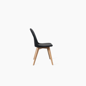 Side view of the Yann dining chair by Vincent Sheppard, featuring a black woven seat and backrest with a natural oak base