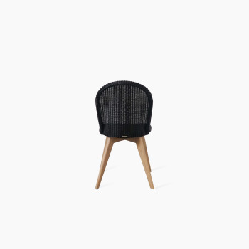 Back view of the Yann dining chair by Vincent Sheppard, featuring a black woven seat and backrest with a natural oak base