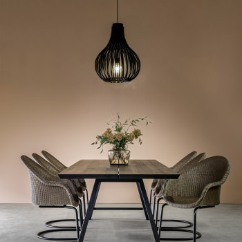 Dining room featuring Avril HB dining chairs with a cantilever base in copper with Lloyd Loom seats, paired with the Albert dining table and a black Bulb pendant lamp, set against a soft pink wall.