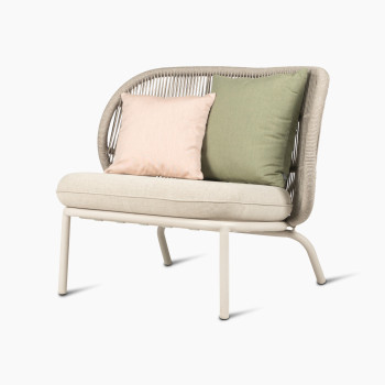 Fauteuil lounge Kodo par Vincent Sheppard en blanc Dune avec siège amande et coussins blush et vert olive, vue à 45 degrés.