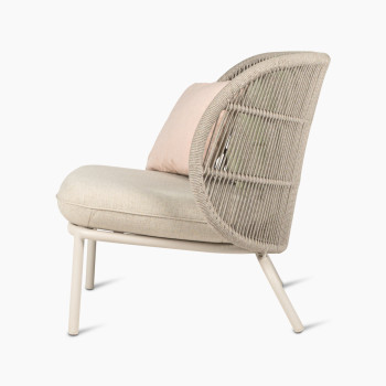 Kodo lounge chair by Vincent Sheppard in Dune white with almond seat, blush, and olive green cushions, side view.