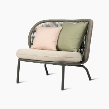 Kodo lounge stoel in fossielgrijs met amandelkleurige zitting en sierkussens in blush en olijfgroen van Vincent Sheppard, 45 graden zicht.