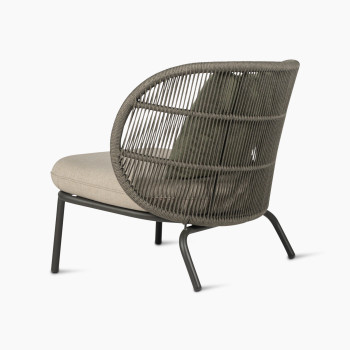 Kodo lounge chair in fossil grey by Vincent Sheppard with almond seat and decorative cushions in blush and olive green, 135-degree view.