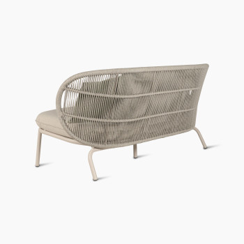 Vue arrière du canapé lounge Kodo en blanc Dune avec coussin de siège amande et coussins décoratifs en vert olive et blush par Vincent Sheppard.