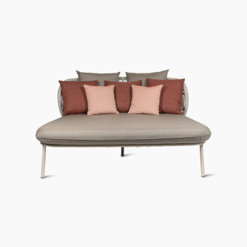 Front view of the Vincent Sheppard Kodo daybed in dune white with a carbon beige seat, featuring terracotta and blush decorative cushions against a curved woven backrest.