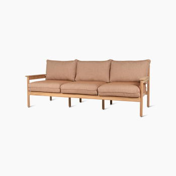 Zijaanzicht van de Vincent Sheppard Oda 3-zits loungesofa met licht houten frame, voorzien van kussens en armleuningen in Sienna-stof.