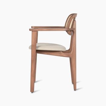 Side view of a Titus dining armchair in tobacco beech wood with a woven cane backrest and an upholstered lime white bouclé seat.