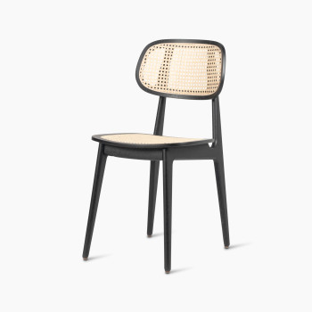 45-degree view of a Titus dining chair in black stained oak with a woven cane backrest and seat.