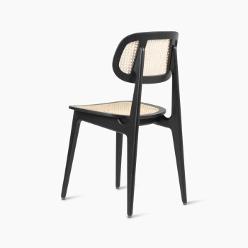 135-degree view of a Titus dining chair in black stained oak with a woven cane backrest and seat.