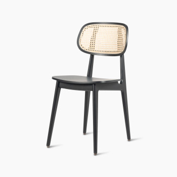  45-degree view of a Titus dining chair in black stained oak with a woven cane backrest and a solid black plywood seat.