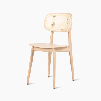 45-degree view of a Titus dining chair in natural varnished oak with a woven cane backrest and a solid plywood seat.