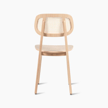 Back view of a Titus dining chair in natural varnished oak with a woven cane backrest and a solid plywood seat.