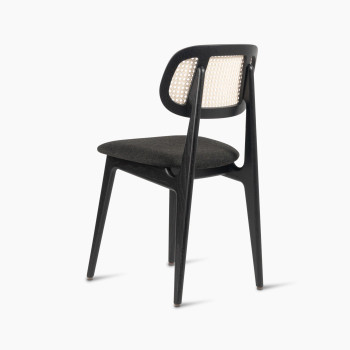  Titus dining chair in black stained oak with a rattan backrest and upholstered seat, rear three-quarter view.