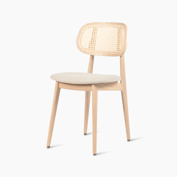 Titus dining chair in natural varnished oak with a rattan backrest and lime white bouclé upholstered seat, angled side view.