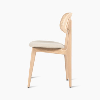 Titus dining chair in natural varnished oak with a rattan backrest and lime white bouclé upholstered seat, side profile view.